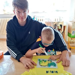 Deváťáci pomáhají s tričky, kde to jde