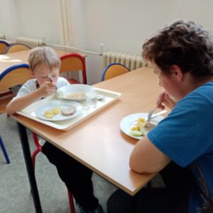 Prvňák s deváťákem u stolu v jídelně